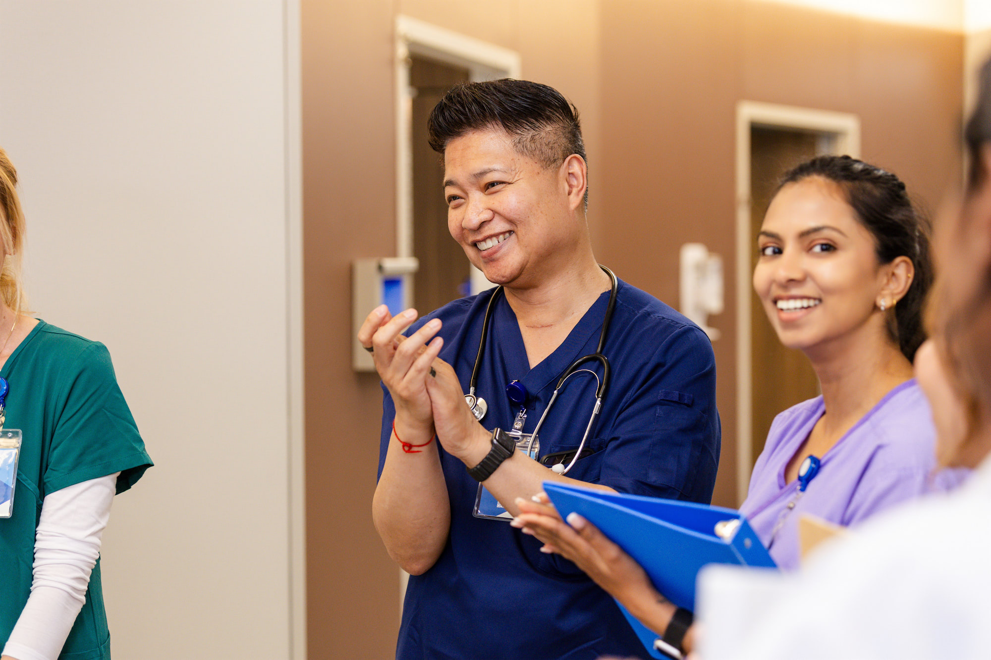 Diverse clinical team collaborating in hospital hallway
